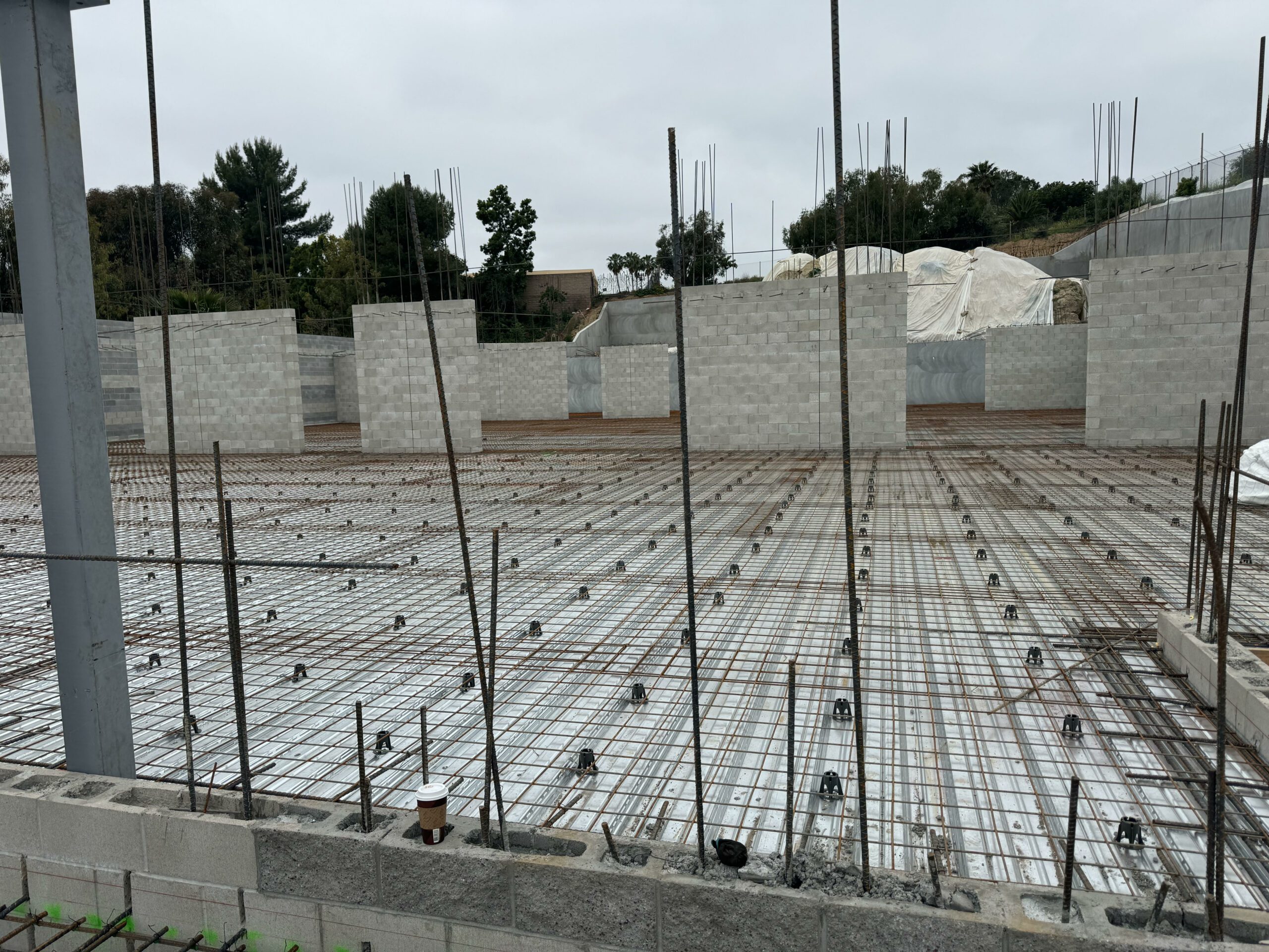 Construction site with extensive rebar framework and concrete blocks under development, highlighting OCFA methane mitigation strategies in building construction.